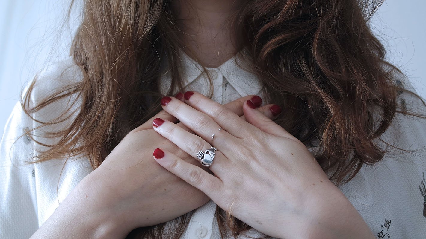 A women places her hand on her heart a symbol for holistic healing - Katharina Treder psychotherapy online and in person
